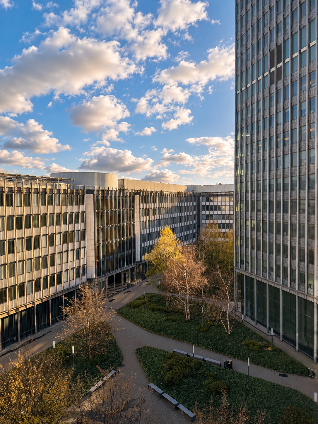 Campus courtyard between modern buildings under a blue sky